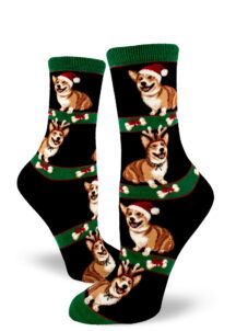 Corgis dressed in Santa hats and reindeer antlers smile on these cute women's Christmas socks in black.