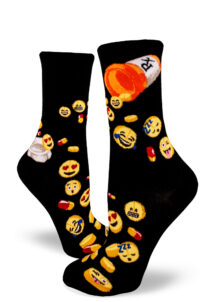 Pills with emoji faces pour out of prescription bottles on black women's crew socks.