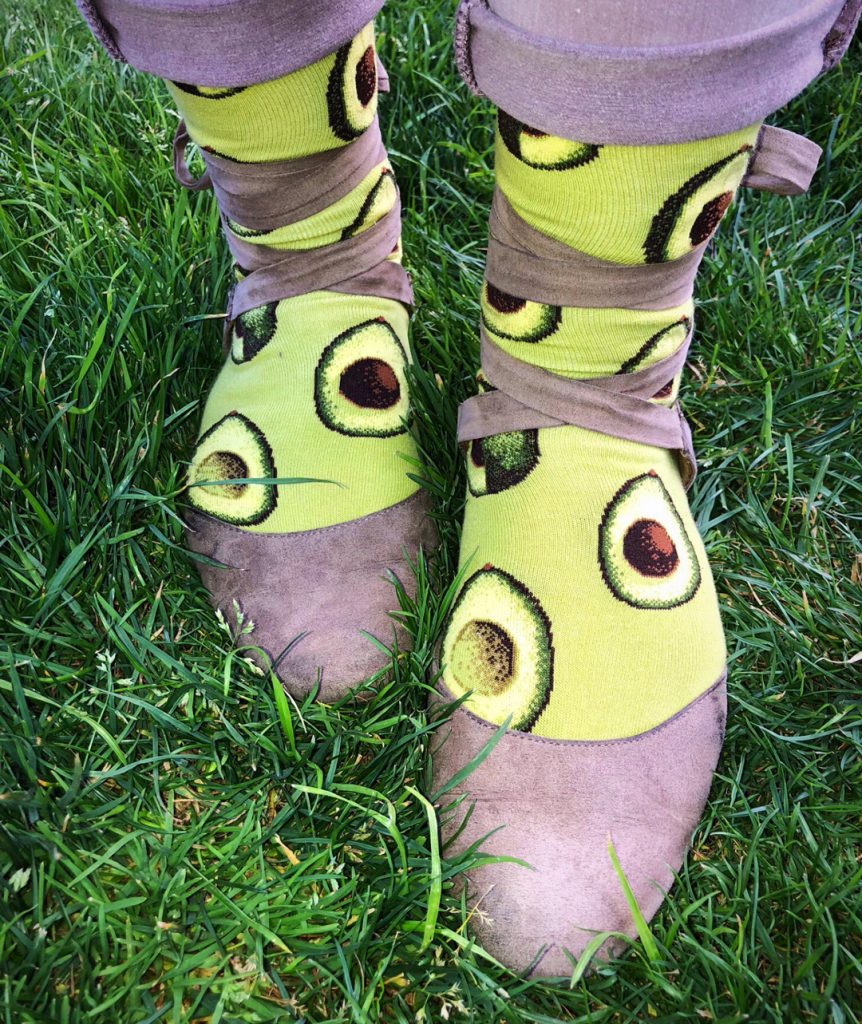 Avocado socks by ModSocks with ripe avocados freshly cut like moon phases.