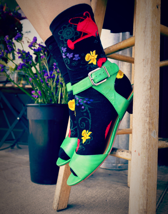 Gardening socks with a red watering can pouring out a variety of flowers by ModSocks.