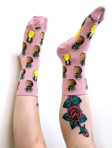 Pineapple socks in pink by ModSocks worn by woman with tattoo.