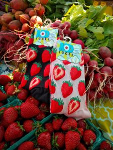 Strawberry socks by ModSocks with sweet strawberries at a farmer's market.