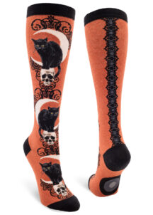 Heather sienna knee socks with a design featuring a black cat hunched on a skull in front of a crescent moon.