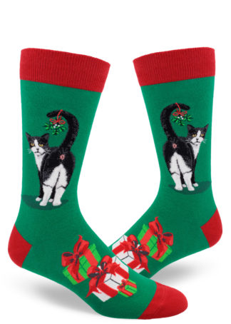 A sprig of mistletoe hangs from a tuxedo cat's tail as he shows off his butthole on these funny novelty Christmas socks for men.
