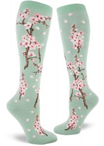Cherry blossom knee socks with a pink floral design on a light green background.