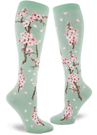 Cherry blossom knee socks with a pink floral design on a light green background.