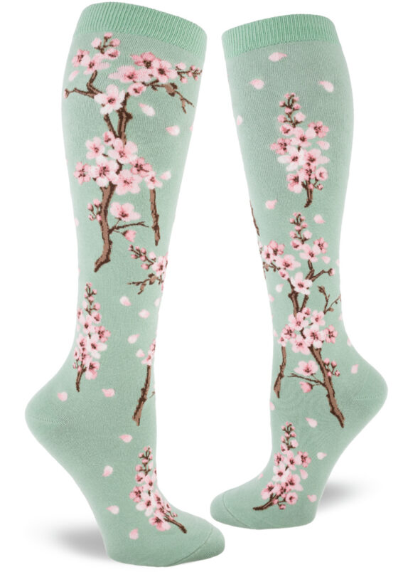 Cherry blossom knee socks with a pink floral design on a light green background.