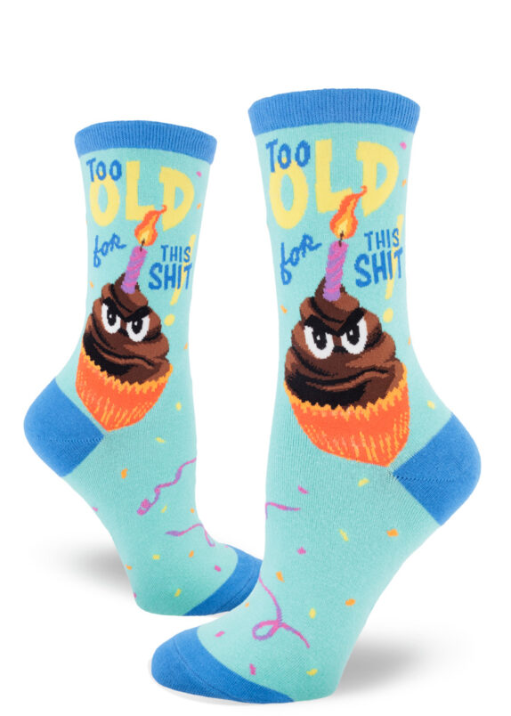 Funny women's crew socks that say "Too old for this shit!" on the side have an image of a grumpy cupcake with a flaming birthday candle.