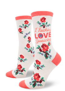 Women's crew socks that say "I fucking love swearing" with a design of red roses and small blue flowers on a heather cream background.