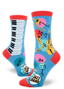 Blue women's crew socks accented in red feature a trombone, saxophone, trumpet, double bass, piano keys, music notes and a drum set that says "Jazz Band" on the bass drumhead.