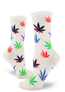 Women's crew socks with a colorful repeating glitch art marijuana leaf pattern over a heather cream background.