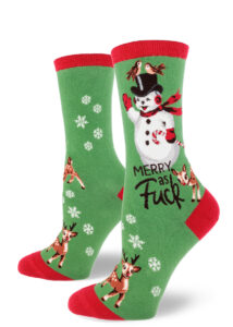 Red-accented green women's crew socks say "Merry as Fuck" and feature a kitschy retro waving snowman holding a candy cane, cute baby reindeer, a pair of birds and a flurry of snowflakes.