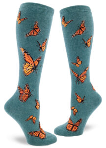 Women's knee-high socks with a vibrant monarch butterfly design on dark teal background called "heather sea."