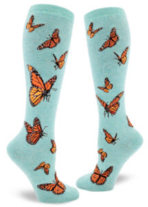Women's knee-high socks with a vibrant monarch butterfly design on an aqua background called "heather verdigris."