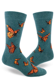 Men's crew socks with a vibrant monarch butterfly design on dark teal background called "heather sea."
