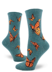 Women's crew socks with a vibrant monarch butterfly design on dark teal background called "heather sea."
