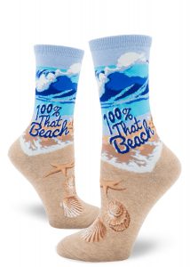 A great wave crashes on the sandy beach on these ocean-themed novelty socks that say "100% That Beach."