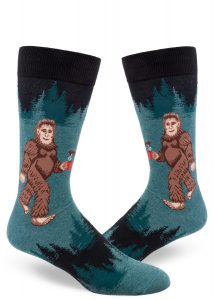 Sasquatch socks feature an image of Bigfoot drinking a mug of coffee in the forest.