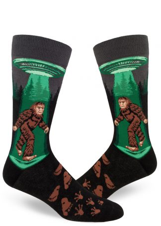 Sasquatch is beamed up into a UFO on these funny men's bigfoot socks.