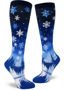 Snowflake knee socks depict a winter scene over a blue gradient striped sky.