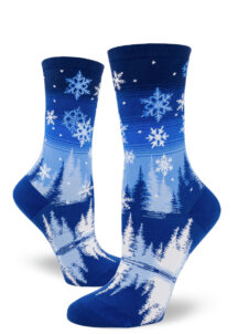 Snowflake crew socks depict a winter scene over a blue gradient striped sky.