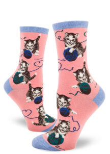 Kittens play with balls of yarn on these peach novelty socks with blue accents.