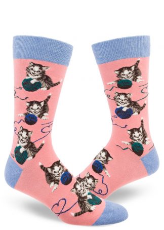 Kittens play with balls of yarn on these peach men's novelty socks with blue accents.