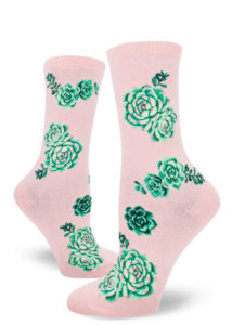 Women's crew socks with a design of green, purple and pink succulent plants on a pink background.